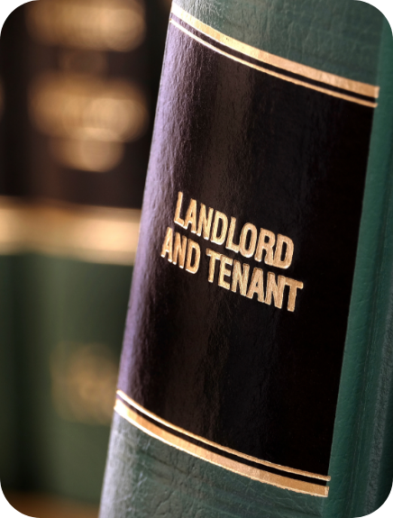 Close-up of a legal book spine labeled ‘Landlord and Tenant,’ with other law books blurred in the background.